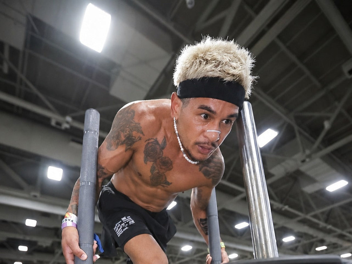 Hybrid race athlete driving a sled push on an indoor race floor
