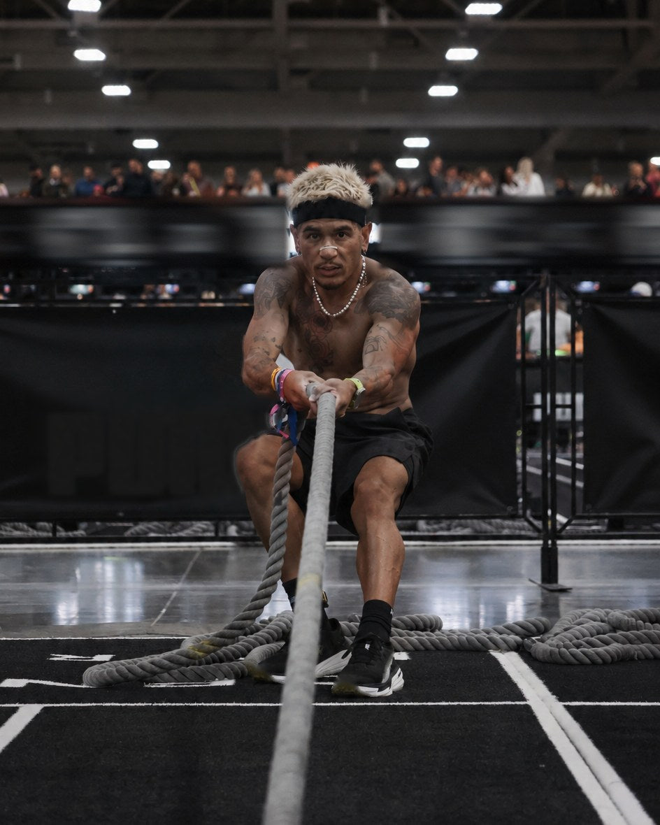 New State founder pulling a heavy sled rope hand over hand during a hybrid fitness race