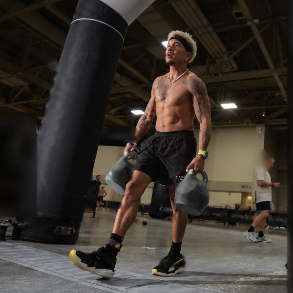 New State founder doing a kettlebell farmers carry during a hybrid fitness race